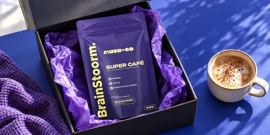 Busta di Brainstoorm di Mush N Go nella sua scatola nera aperta con carta velina viola e una tazza schiumosa su fondo blu
